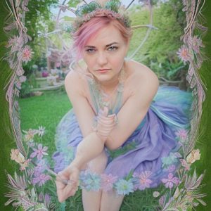Photo of Andrea Breanna wearing a purple and blue gauze dress and flower crown sitting in the grass